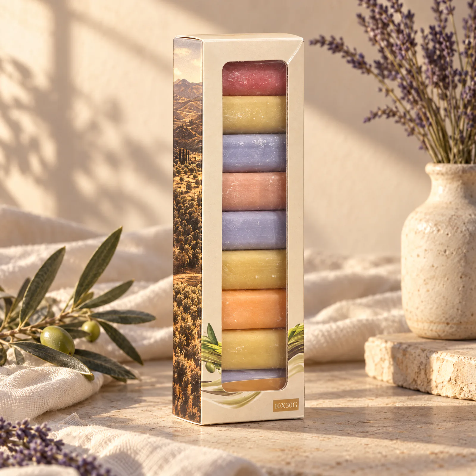 Étui à fenêtre de dix mini savons colorés posé sur un drapé crème